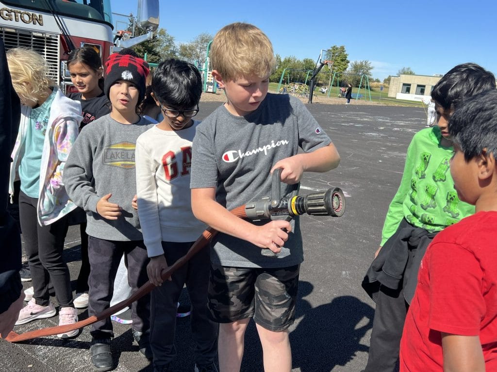 Student holding a fire hose