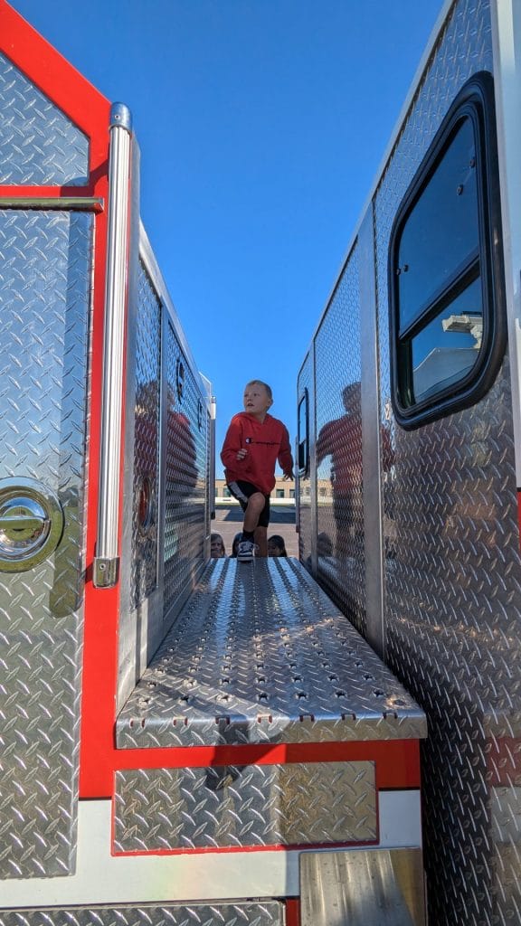 Student climbing on fire truck