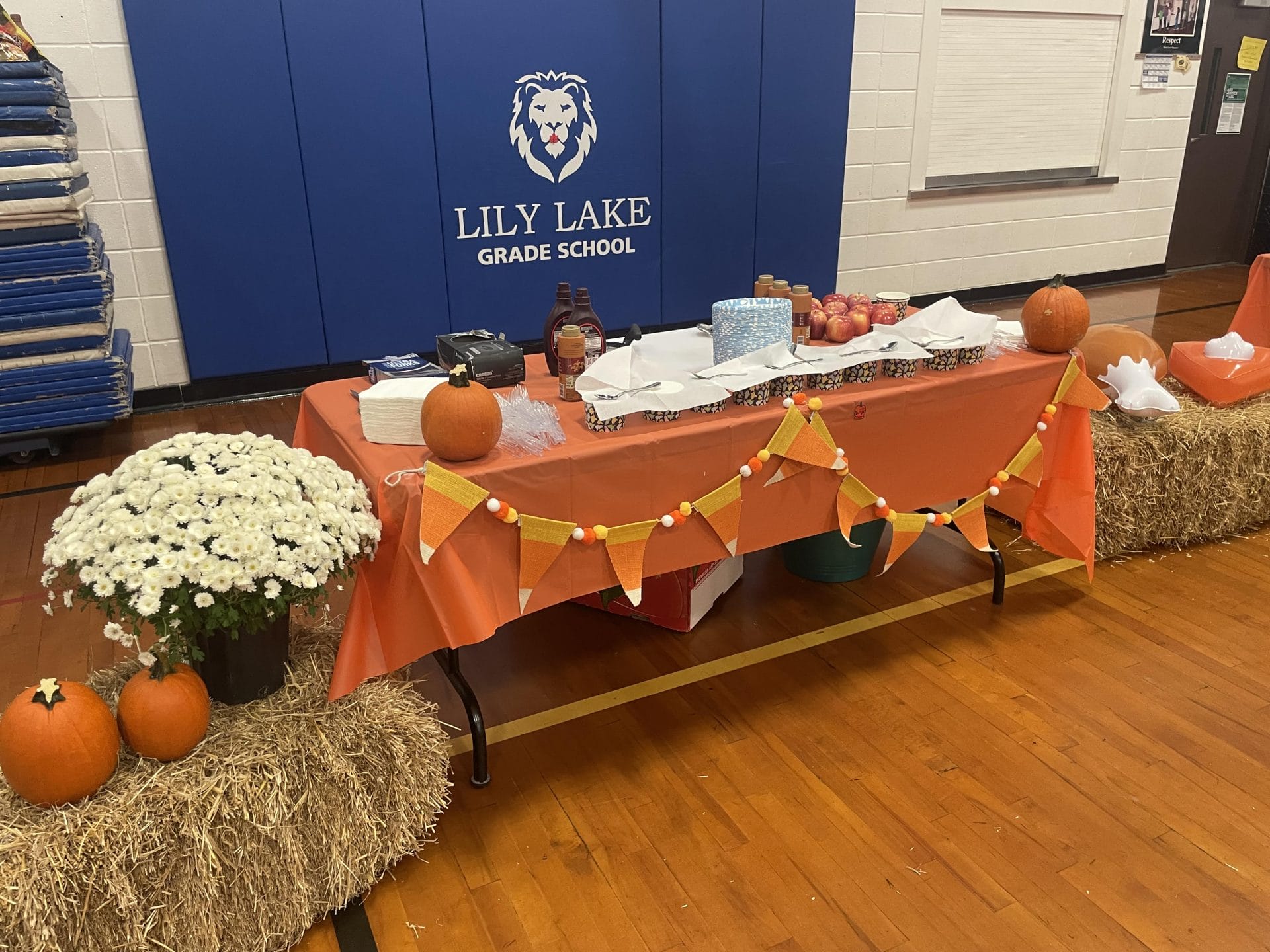 Fall table with pumpkins, food, mums, and hay