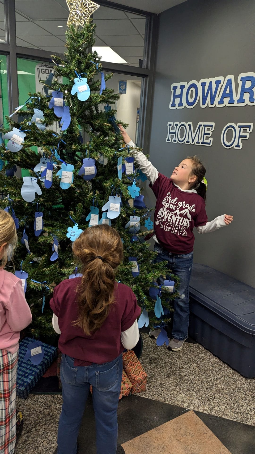 Two students taking a tag from the giving tree