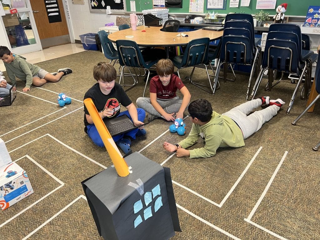 Group of fourth graders coding their robot.