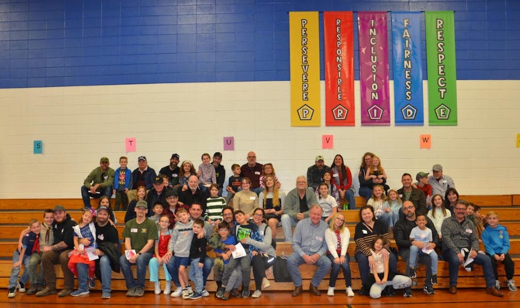 Veterans and students on bleacher after the assembly.