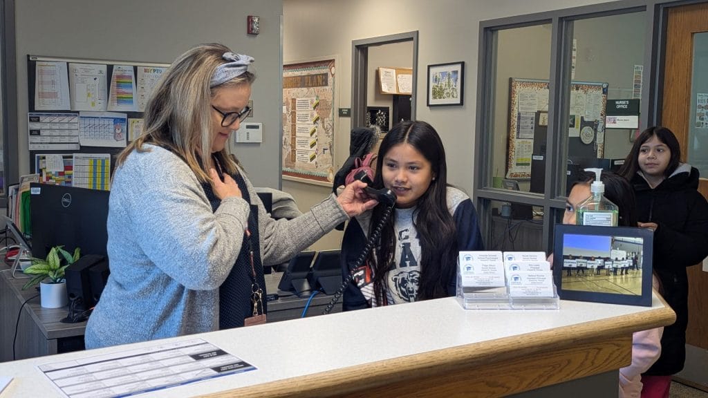 Student on a phone in a school office