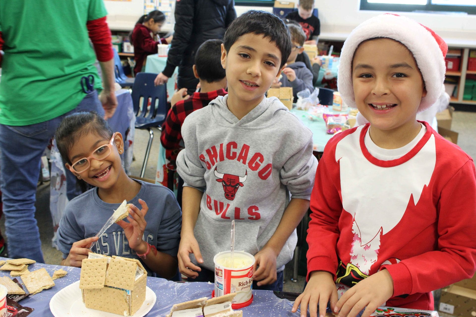 2nd graders making gingerbread houses
